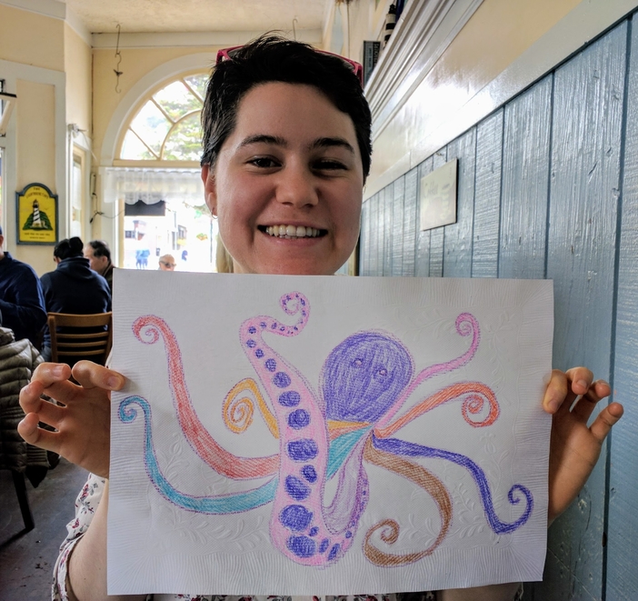 A picture of me holding a multi-colored crayon drawing of an octopus.